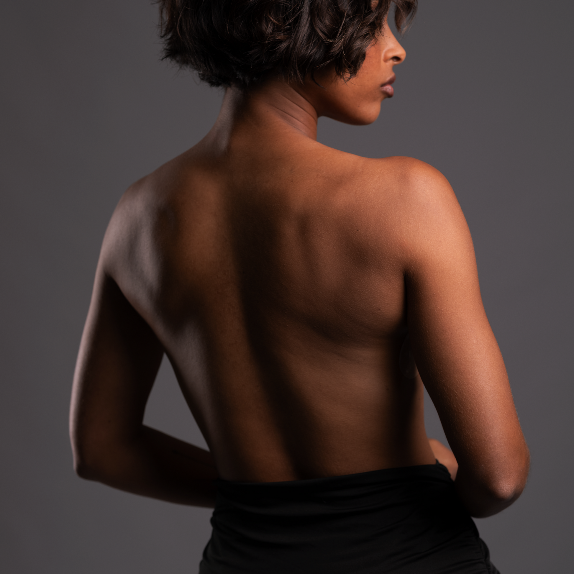 Model wearing the go bare backless strapless bra from behind, showing that it doesn't show in the back.