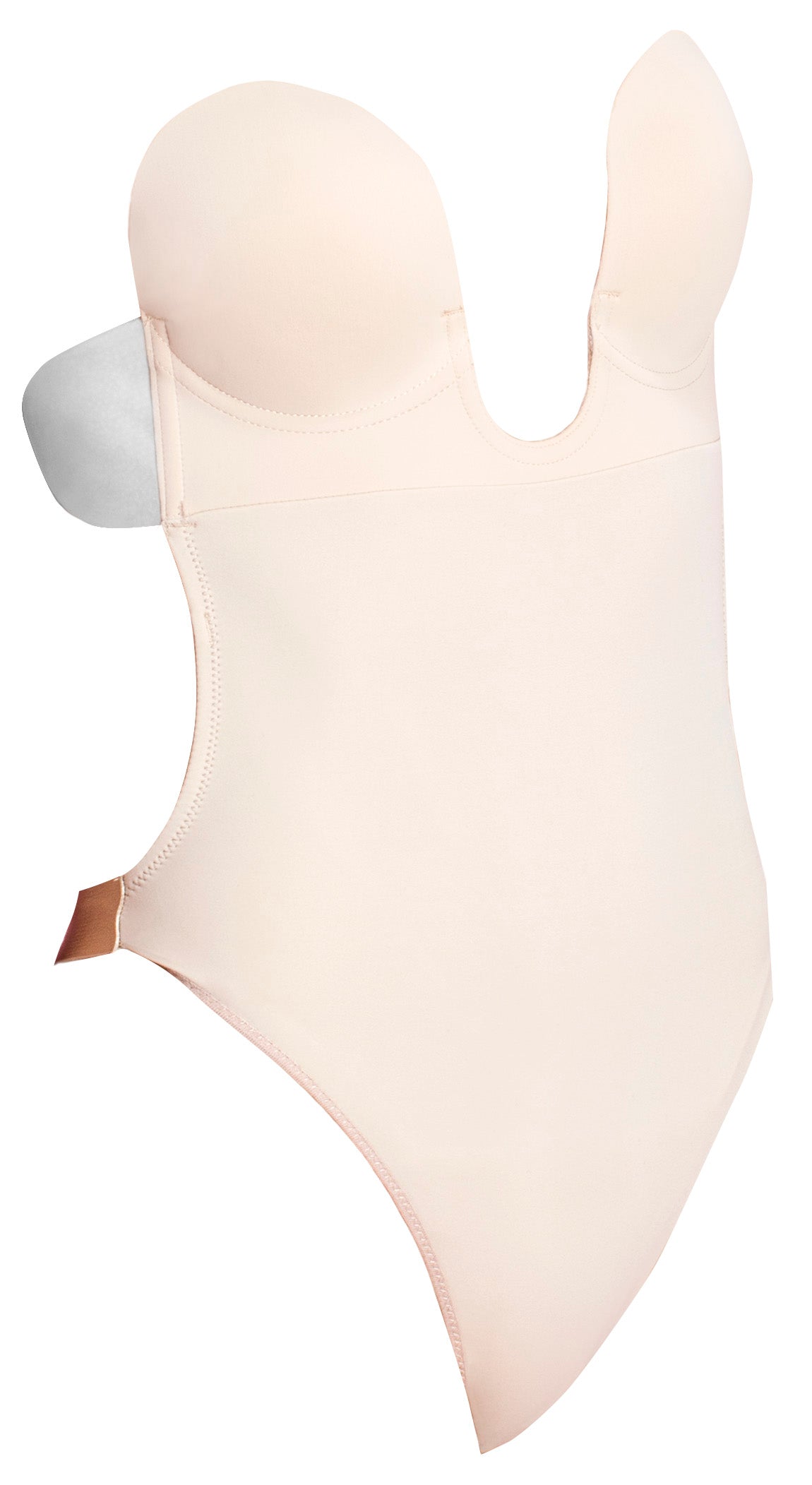 Product image of the U plunge backless strapless bodysuit in nude. It is in the shape of a one-piece swimsuit, no straps or upper back. There are adhesive flaps on either side of the upper portion of the suit, under the cups.