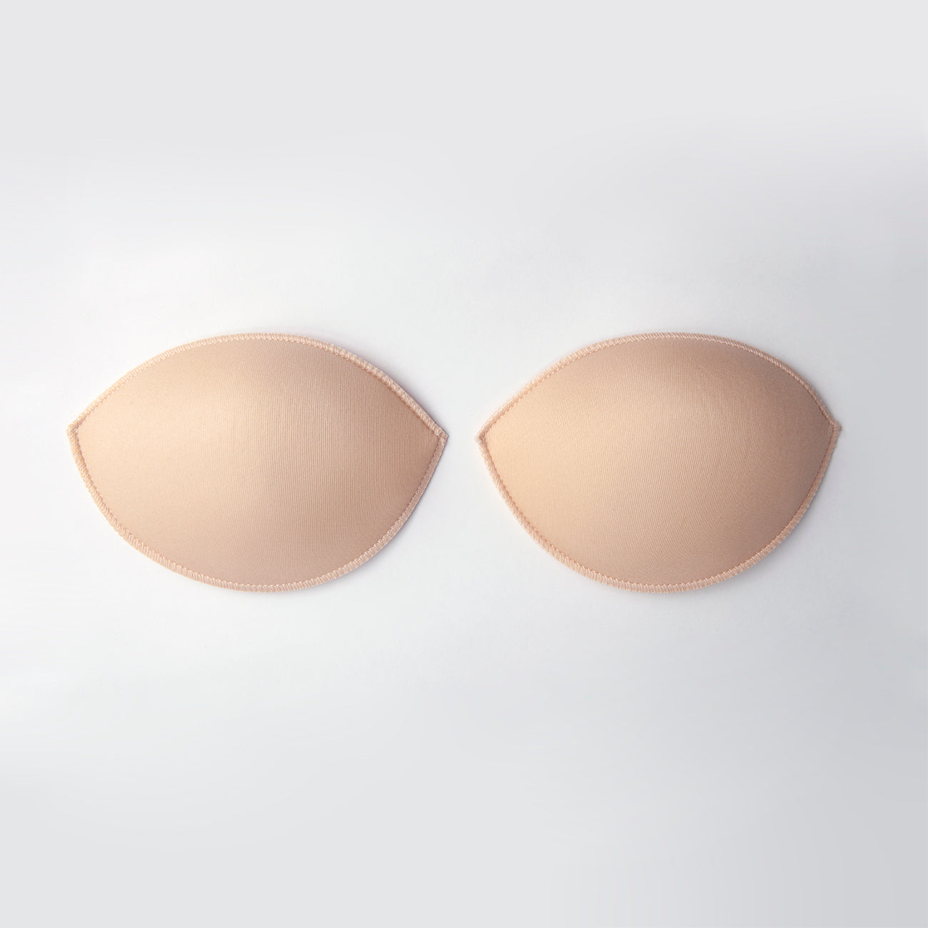 Product image of the water push up pads. They are ovals with tapered points on either side. They are nude and soft nylon on the outside