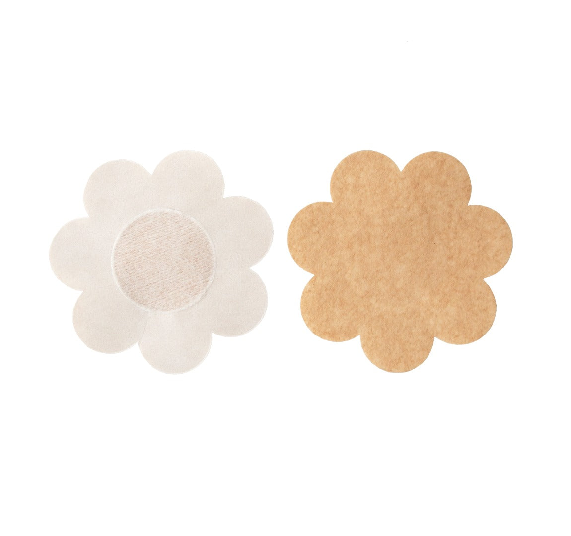 Close up of the disposable petals. There is a soft cotton enter for the nipple, with the adhesive surrounding the center. The petal is a flower shape. The petals are nude in color.
