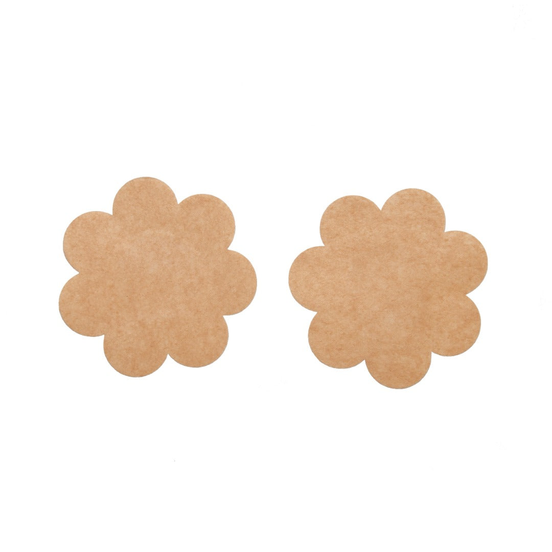 Close up of the disposable petals. There is a soft cotton enter for the nipple, with the adhesive surrounding the center. The petal is a flower shape. The petals are nude in color.