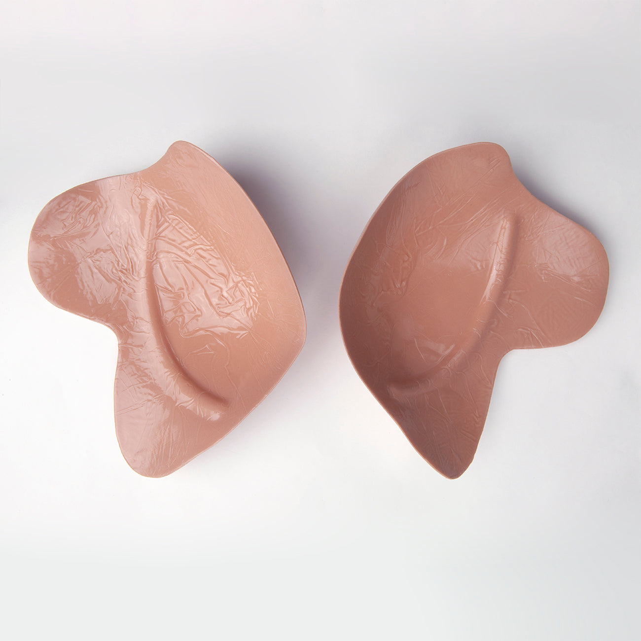 Inside shot of the le lusion bra. The outside is facing down. You can see where it will form to your body. The entire inside is adhesive. Bra is light tan in color.