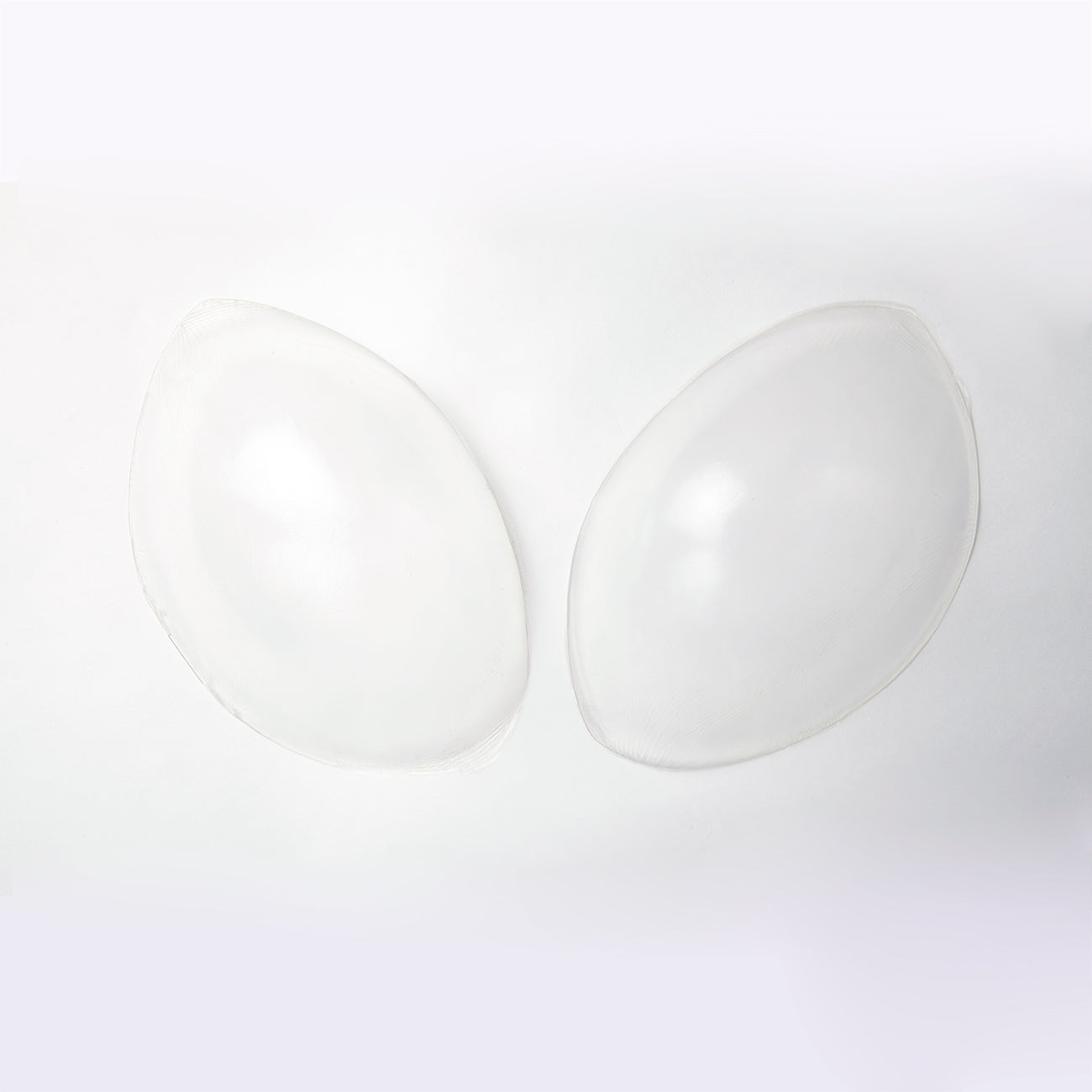 Outside image of the silicone skin bra. It is clear and is oval shaped. The edges of the oval come to points on either side.