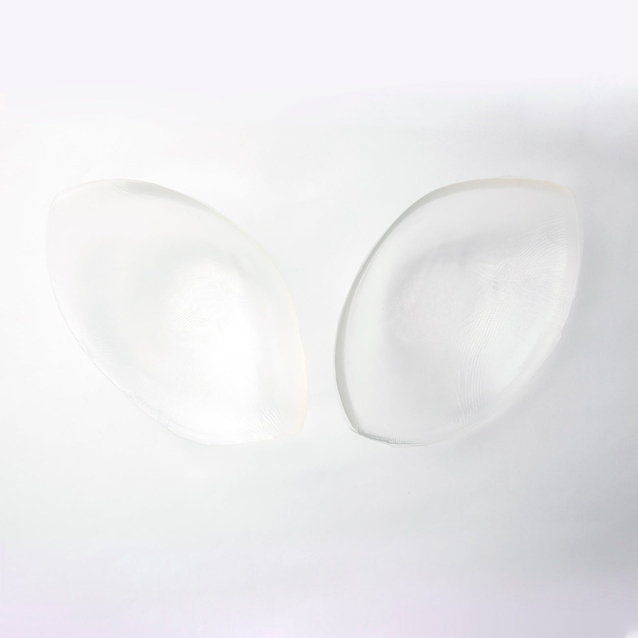 Inside image of the silicone skin bra. It is clear and is oval shaped. The edges of the oval come to points on either side.