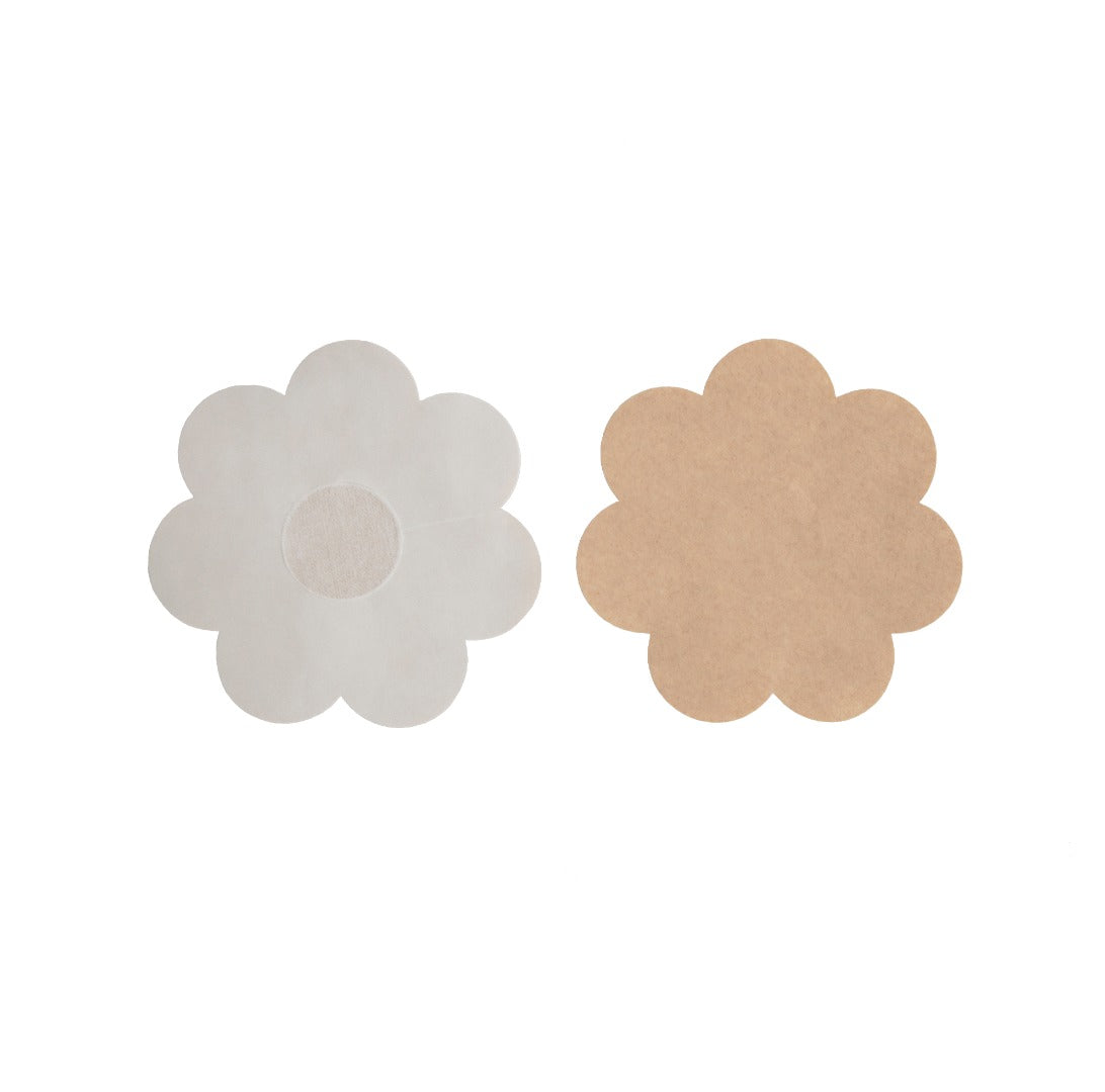 Close up of the full figure disposable petals. There is a soft cotton enter for the nipple, with the extra space of adhesive surrounding the center. The petal is a flower shape. Petals are nude in color.